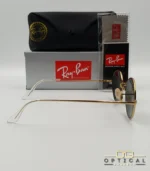 Lunettes de soleil de luxe Ray-Ban Oval RB1970 dorées avec verres foncés, étui en cuir et packaging d'origine - Optical Gallery.