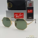 Lunettes de soleil octogonales Ray-Ban RB1972 avec monture fine en métal doré, verres verts et manchons écaillés, présentées avec leur étui noir - Optical Gallery.
