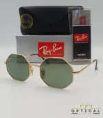 Lunettes de soleil octogonales Ray-Ban RB1972 avec monture fine en métal doré, verres verts et manchons écaillés, présentées avec leur étui noir - Optical Gallery.
