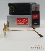Lunettes de soleil octogonales Ray-Ban RB1972 avec monture fine en métal doré, verres verts et manchons écaillés, présentées avec leur étui noir - Optical Gallery.