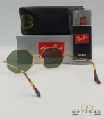 Lunettes de soleil octogonales Ray-Ban RB1972 avec monture fine en métal doré, verres verts et manchons écaillés, présentées avec leur étui noir - Optical Gallery.