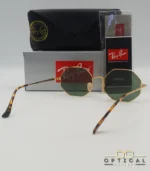 Lunettes de soleil octogonales Ray-Ban RB1972 avec monture fine en métal doré, verres verts et manchons écaillés, présentées avec leur étui noir - Optical Gallery.