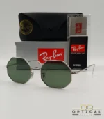 Lunettes de soleil géométriques octogonales Ray-Ban RB1972 dorées avec verres verts, présentées avec leur étui en cuir marron et le logo Optical Gallery.