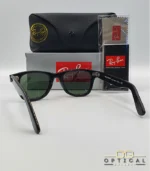 Lunettes de soleil Ray-Ban Wayfarer RB2140 noires avec verres verts G-15, présentées avec leur étui noir, leur boîte grise et leur kit de nettoyage, le tout sur fond blanc avec le logo Optical Gallery.