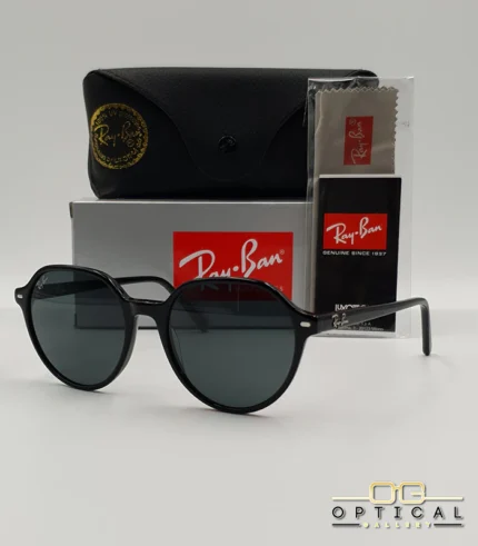 Lunettes de soleil Ray-Ban Thalia RB2195 avec monture en acétate noir brillant et verres teintés foncés, présentées avec leur étui noir et le logo Optical Gallery.