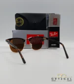 Lunettes de soleil Ray-Ban Clubmaster RB3016 monture écaille de tortue et métal doré avec verres marrons, étui et boîte d'origine.