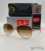 Lunettes de soleil Ray-Ban Aviator RB3025 monture métallique or rose avec verres dégradés marrons, étui et boîte d'origine.