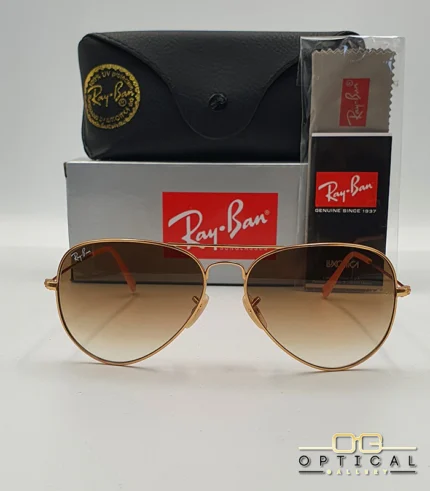 Lunettes de soleil Ray-Ban Aviator RB3025 monture métallique or rose avec verres dégradés marrons, étui et boîte d'origine.