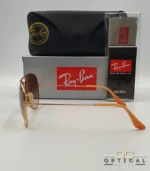 Lunettes de soleil Ray-Ban Aviator RB3025 monture métallique or rose avec verres dégradés marrons, étui et boîte d'origine.