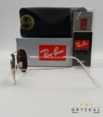 Lunettes de soleil Ray-Ban Aviator RB3025 monture métallique dorée avec verres noirs, étui et boîte d'origine.