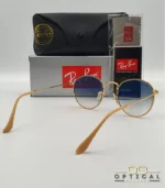 Lunettes de soleil Ray-Ban Round Metal RB3447 monture métallique dorée avec verres dégradés bleus, étui et boîte d'origine.
