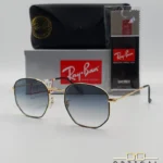 Lunettes de soleil Ray-Ban Hexagonal Flat Lenses RB3548N monture bicolore en métal doré et cerclage noir avec verres dégradés gris-bleu, étui et boîte d'origine.