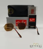 Lunettes de soleil Ray-Ban Octagonal RB3556 dorées avec verres marrons, étui noir, boîte et certificat Luxottica.