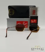 Lunettes de soleil Ray-Ban Octagonal RB3556 dorées avec verres marrons, étui noir, boîte et certificat Luxottica.
