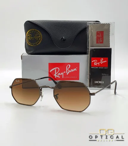 Lunettes de soleil Ray-Ban Octagonal RB3556 marron bronze avec verres dégradés marrons, étui noir, boîte grise et livret Luxottica.
