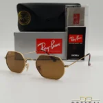 Lunettes de soleil Ray-Ban Octagonal RB3556 dorées avec verres marrons, étui noir, boîte et certificat Luxottica.