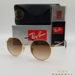 Lunettes de soleil Ray-Ban Jack RB3565 dorées avec verres dégradés marrons, étui noir, boîte grise et livret de garantie chez Optical Gallery.