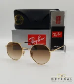 Lunettes de soleil Ray-Ban Jack RB3565 dorées avec verres dégradés marrons, étui noir, boîte grise et livret de garantie chez Optical Gallery.