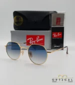 Lunettes de soleil Ray-Ban Jack RB3565 dorées avec verres dégradés bleus, étui noir, boîte grise et livret de garantie chez Optical Gallery.