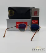 Lunettes de soleil Ray-Ban Jack RB3565 dorées avec verres dégradés bleus, étui noir, boîte grise et livret de garantie chez Optical Gallery.