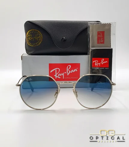 Lunettes de soleil Ray-Ban Jack RB3565 argentées avec verres dégradés bleus gris, étui noir, boîte grise et livret de garantie chez Optical Gallery.