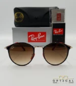Lunettes de soleil Ray-Ban Scuderia Ferrari RB3602M noires et dorées avec verres dégradés marrons, étui noir, boîte grise et livret de garantie chez Optical Gallery.