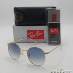 Lunettes de soleil Ray-Ban New Round RB3637 dorées avec verres dégradés bleus gris, étui noir, boîte grise et livret de garantie chez Optical Gallery.