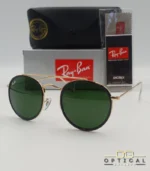 Lunettes de soleil Ray-Ban Round Double Bridge RB3647N dorées avec cerclages en acétate noir et verres verts G-15, étui noir, boîte grise et livret de garantie chez Optical Gallery.