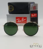 Lunettes de soleil Ray-Ban Round Double Bridge RB3647N dorées avec cerclages en acétate noir et verres verts G-15, étui noir, boîte grise et livret de garantie chez Optical Gallery.