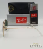 Lunettes de soleil Ray-Ban Round Double Bridge RB3647N dorées avec cerclages en acétate noir et verres verts G-15, étui noir, boîte grise et livret de garantie chez Optical Gallery.