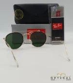 Lunettes de soleil Ray-Ban Round Double Bridge RB3647N dorées avec cerclages en acétate noir et verres verts G-15, étui noir, boîte grise et livret de garantie chez Optical Gallery.