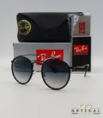 Lunettes de soleil Ray-Ban Round Double Bridge RB3647N noires avec cerclages en acétate noir et verres dégradés bleus gris, étui noir, boîte grise et livret de garantie chez Optical Gallery.