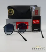 Lunettes de soleil Ray-Ban Round Double Bridge RB3647N noires avec cerclages en acétate noir et verres dégradés bleus gris, étui noir, boîte grise et livret de garantie chez Optical Gallery.