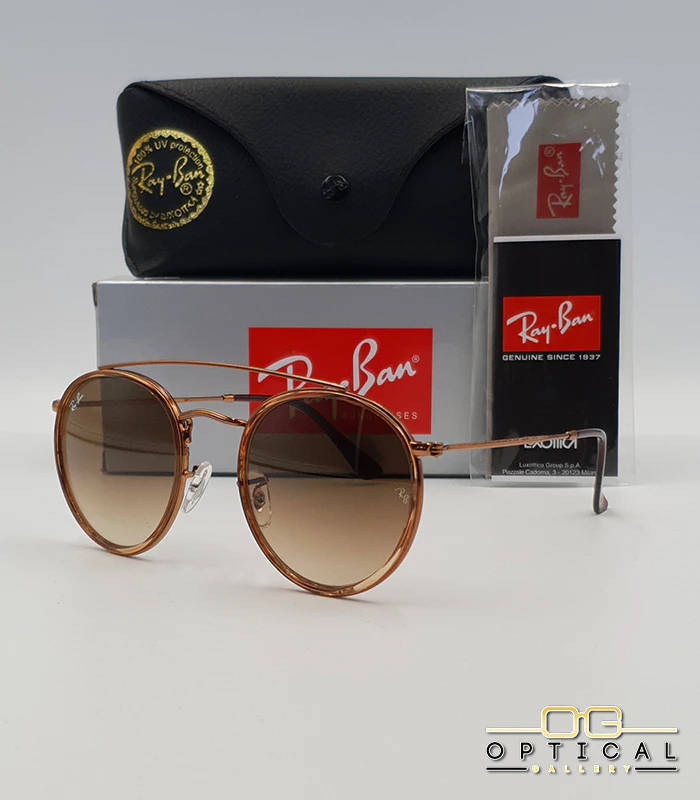 lunettes-de-soleil-ray-ban-round-double-bridge-rb3647n-marron-degrade-optical-gallery Lunettes de soleil Ray-Ban Round Double Bridge RB3647N marrons avec cerclages en acétate transparent marron et verres dégradés marrons, étui noir, boîte grise et livret de garantie chez Optical Gallery.