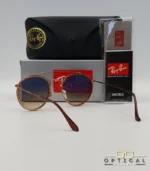 Lunettes de soleil Ray-Ban Round Double Bridge RB3647N marrons avec cerclages en acétate transparent marron et verres dégradés marrons, étui noir, boîte grise et livret de garantie chez Optical Gallery.