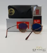 Lunettes de soleil Ray-Ban Round Double Bridge RB3647N marrons avec cerclages en acétate transparent marron et verres dégradés marrons, étui noir, boîte grise et livret de garantie chez Optical Gallery.