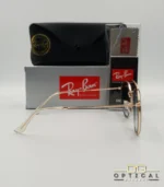 Lunettes de soleil Ray-Ban Round Double Bridge RB3647N dorées avec cerclages en acétate transparent et verres dégradés bleus, étui noir, boîte grise et livret de garantie chez Optical Gallery.