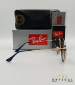 Lunettes de soleil Ray-Ban Round Double Bridge RB3647N dorées avec cerclages en acétate bleu marine et verres dégradés bleus marrons, étui noir, boîte grise et livret de garantie chez Optical Gallery.