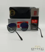 Lunettes de soleil Ray-Ban Round Double Bridge RB3647N argentées avec cerclages en acétate noir et verres dégradés bleus gris, étui noir, boîte grise et livret de garantie chez Optical Gallery.