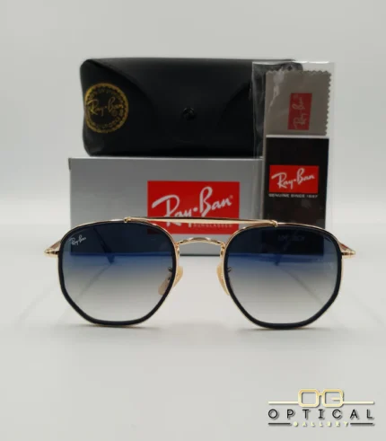 Lunettes de soleil Ray-Ban Marshal II RB3648M dorées avec cerclages en acétate bleu marine et verres dégradés bleus gris, étui noir, boîte grise et livret de garantie chez Optical Gallery.