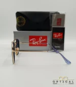 Lunettes de soleil Ray-Ban Marshal II RB3648M dorées avec cerclages en acétate bleu marine et verres dégradés bleus gris, étui noir, boîte grise et livret de garantie chez Optical Gallery.