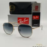 Lunettes de soleil Ray-Ban Marshal II RB3648M dorées avec cerclages en acétate transparent et verres dégradés bleus gris, étui noir, boîte grise et livret de garantie chez Optical Gallery.