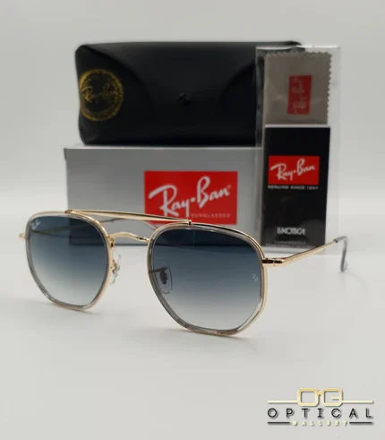 Lunettes de soleil Ray-Ban Marshal II RB3648M dorées avec cerclages en acétate transparent et verres dégradés bleus gris, étui noir, boîte grise et livret de garantie chez Optical Gallery.