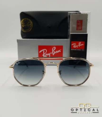 Lunettes de soleil Ray-Ban Marshal II RB3648M dorées avec cerclages en acétate transparent et verres dégradés bleus gris, étui noir, boîte grise et livret de garantie chez Optical Gallery.