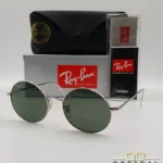 Lunettes de soleil rondes Ray-Ban RB1970 dorées avec verres verts, présentées avec leur étui en cuir noir, leur boîte et le logo Optical Gallery.