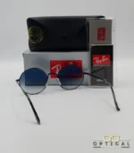 Voici les métadonnées entièrement optimisées pour cette nouvelle fiche produit de votre catalogue Ray-Ban (ray-ban-oval-rb1970-argent-lunettes-de-soleil-7.webp). Ce visuel présente une magnifique variante sombre et métallisée avec des verres dégradés, idéale pour enrichir votre catalogue. Paramètres de l'image : ray-ban-oval-rb1970-argent-lunettes-de-soleil-7.webp (Photo Produit Catalogue / Lunettes de Soleil Ray-Ban) Texte alternatif : Lunettes de soleil rondes Ray-Ban RB1970 avec monture en métal noir ou argent foncé et verres dégradés bleus, présentées avec l'étui officiel et le logo Optical Gallery.