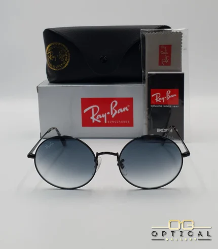 Voici les métadonnées entièrement optimisées pour cette nouvelle fiche produit de votre catalogue Ray-Ban (ray-ban-oval-rb1970-argent-lunettes-de-soleil-7.webp). Ce visuel présente une magnifique variante sombre et métallisée avec des verres dégradés, idéale pour enrichir votre catalogue. Paramètres de l'image : ray-ban-oval-rb1970-argent-lunettes-de-soleil-7.webp (Photo Produit Catalogue / Lunettes de Soleil Ray-Ban) Texte alternatif : Lunettes de soleil rondes Ray-Ban RB1970 avec monture en métal noir ou argent foncé et verres dégradés bleus, présentées avec l'étui officiel et le logo Optical Gallery.