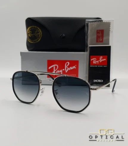 Lunettes de soleil Ray-Ban Marshal II RB3648M argentées avec cerclages en acétate noir et verres dégradés bleus gris, étui noir, boîte grise et livret de garantie chez Optical Gallery.