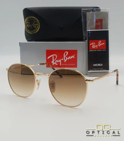 Lunettes de soleil Ray-Ban Julie RB3772 dorées avec verres dégradés marrons, étui noir, boîte grise et livret de garantie chez Optical Gallery.