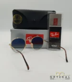 Lunettes de soleil Ray-Ban Julie RB3772 dorées avec verres dégradés bleus gris, étui noir, boîte grise et livret de garantie chez Optical Gallery.